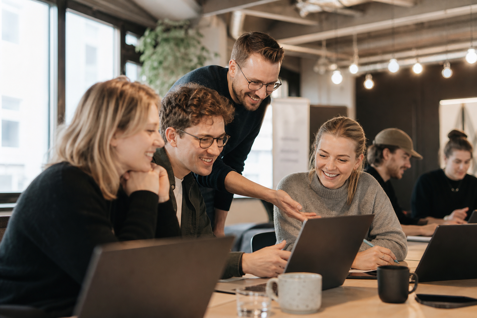 Workshop-Szene mit Mitarbeitern die an Laptops mit einem KI-Tool experimentieren